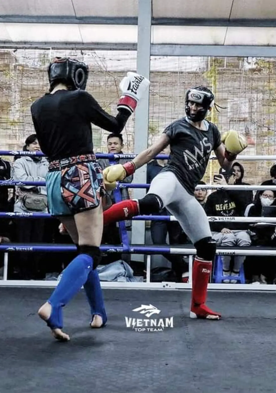 Deux personnes pratiquent le kick-boxing sur un ring